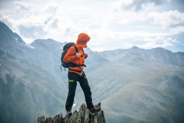 istock Mountaineer scrambles up summit of pinnacle 1366647366