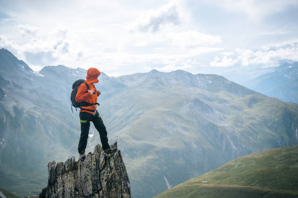 istock Mountaineer scrambles up summit of pinnacle 1366647374