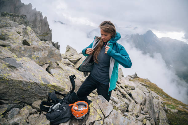 istock Woman mountaineer puts protective gear on, mountain ridge 1366647426