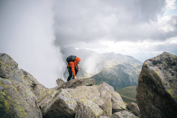 istock Mountaineer scrambles up mountain ridge 1366647475