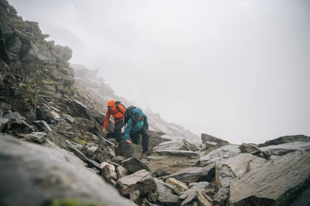 istock Mountaineers scramble up a rocky ridge 1366648168