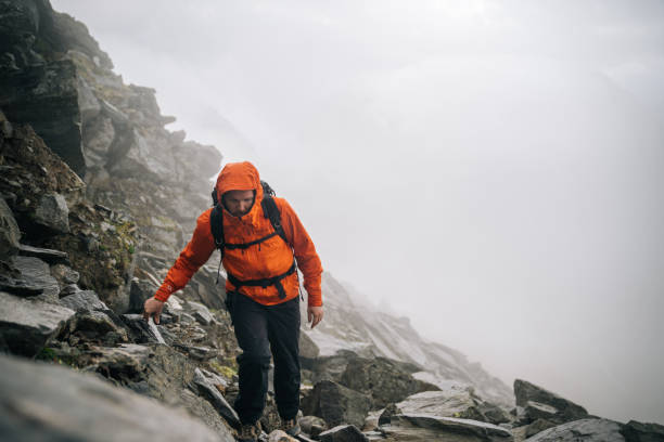 istock Mountaineer scrambles up mountain ridge 1366648300