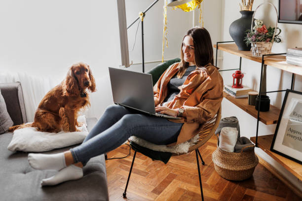 istock Beautiful young student learning at home. Online learning concept. Young woman with her dog working at home office. 1366648878