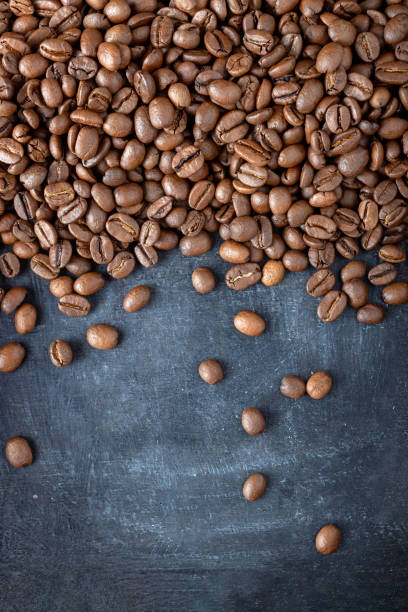 istock coffee beans scattered over gray background, food background 1366649553