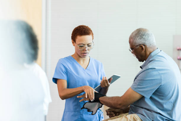 il fisioterapista aiuta il paziente con il tutore per le mani - male nurse black nurse doctor foto e immagini stock