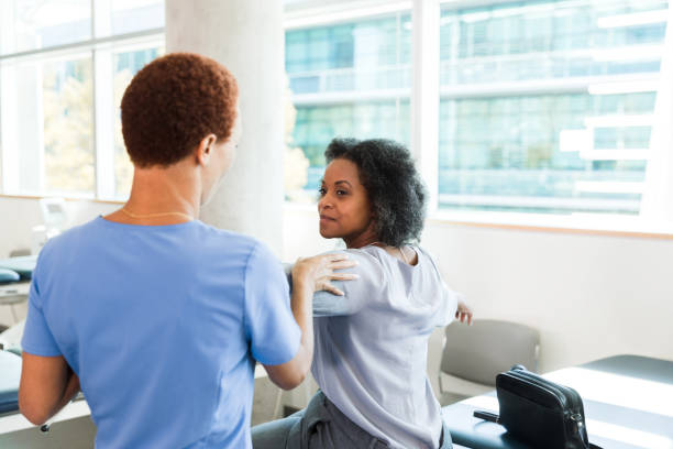 istock Physical therapist helps patient during physical therapy session 1366650116