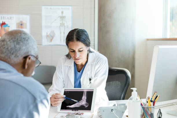 orthopäde bespricht fußröntgen des älteren patienten - podiatrist stock-fotos und bilder