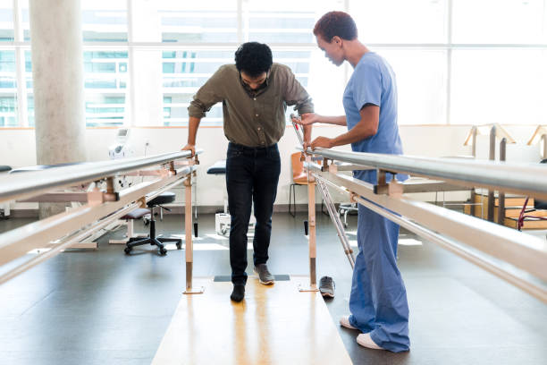 istock Physical therapist helps man walk after injury 1366650131