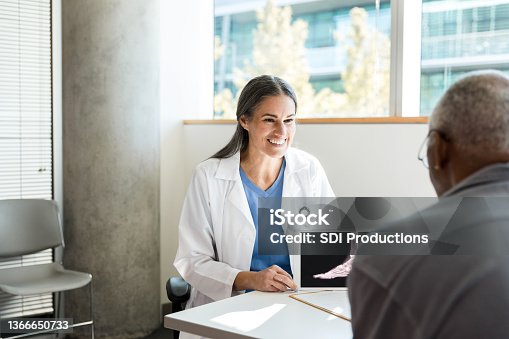 istock Mid adult orthopedic doctor reviews x-ray results with unrecognizable patient 1366650733