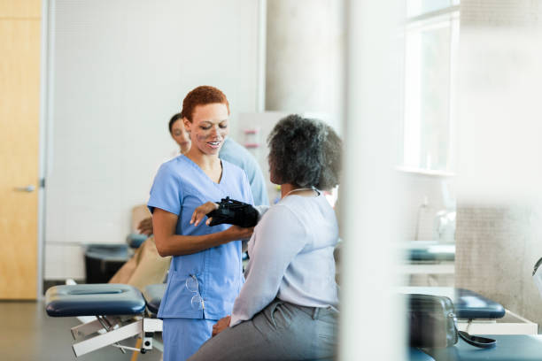 istock Female physical therapist gently examines businesswoman's wrist 1366650738