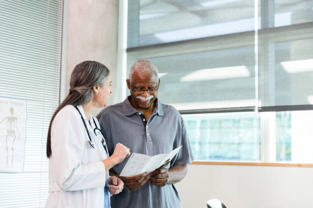 istock Orthopedic doctor and senior patient smile while discussing brochure information 1366650747