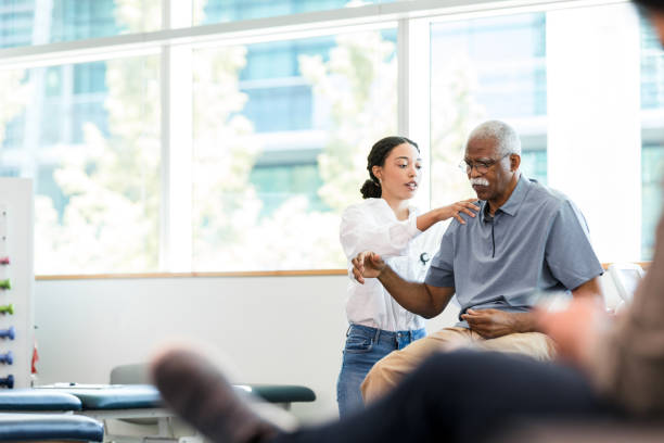 istock Physical therapist examines senior man's shoulder 1366650758