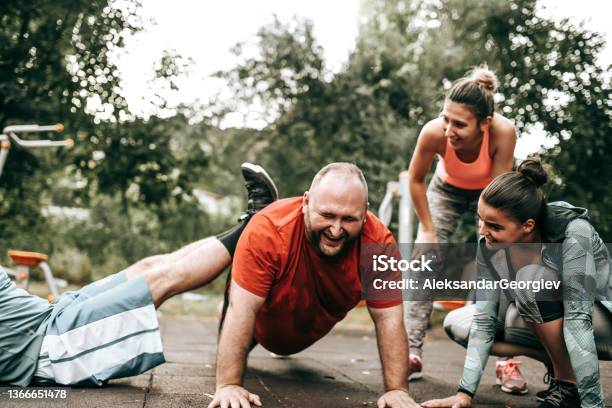 Overweight Male Getting Getting Motivated By Friends To Perform Better During Workouts Stock Photo - Download Image Now