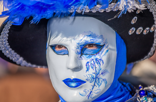 Close up of black and white carnival mask with golden bells at City of Venice on a cloudy summer day. Photo taken August 6th, 2023, Venice, Italy.