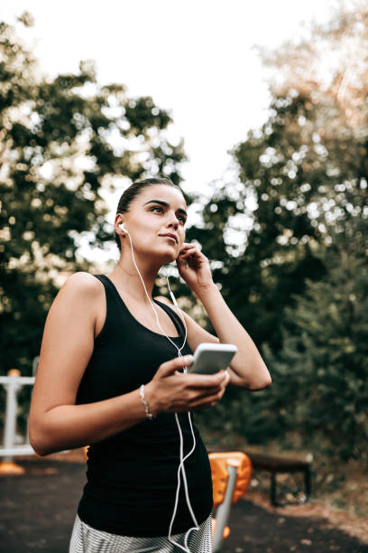 istock Beautiful Athletic Female Setting Up Workout Playlist 1366651712