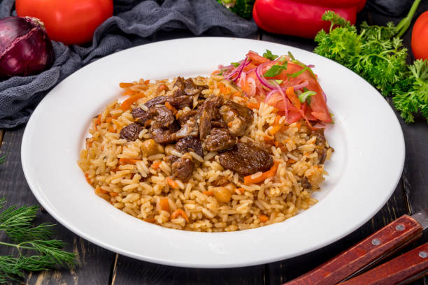 istock pilaf with beef and vegettables salad on white plate on dark table 1366652819