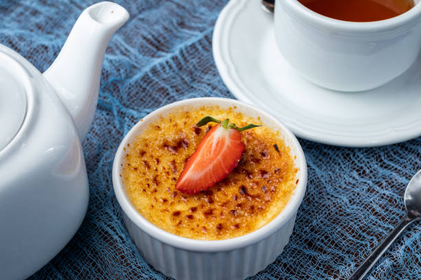 istock classic dessert creme brulee with strawberry on blue table with tea 1366654542