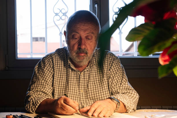 istock Portrait of an elderly man with a concentrated expression while drawing. Old people activities concept. 1366655691