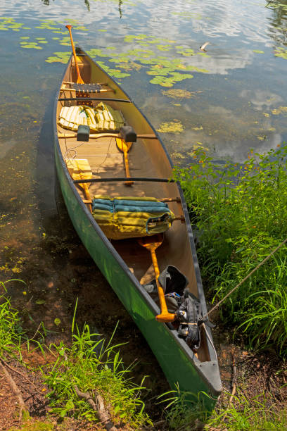 istock Canoe Waiting on Shore for Adventure 1366656981
