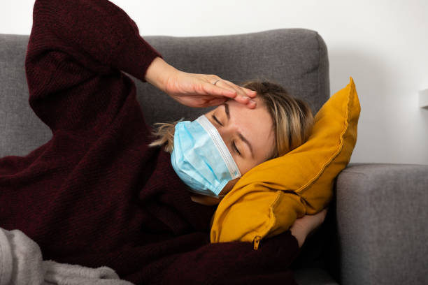 istock Sick woman with protective mask at home 1366657299