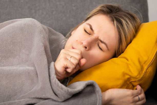 Sick woman lying on the couch stock photo