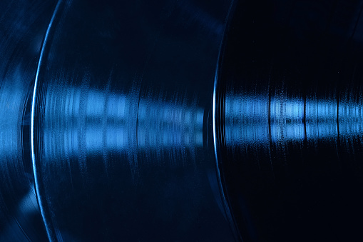 Close-up of blue vinyl. Blue background texture of vinyl records on a dark background.