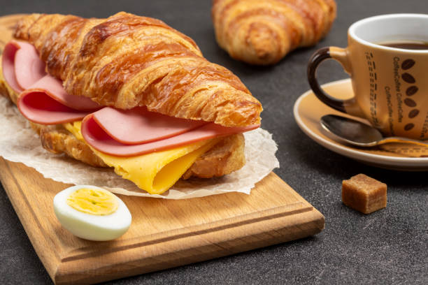 istock Croissant with ham and cheese on board. 1366659876