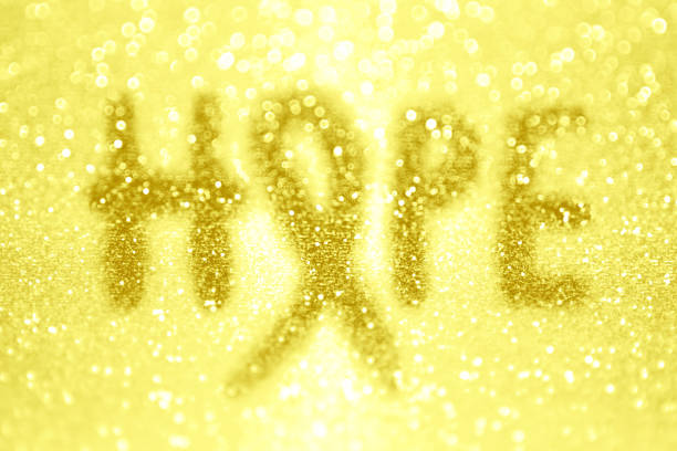 Endometriosis, suicide, and childhood kid cancer awareness ribbon hope month Abstract hope yellow gold ribbon background for awareness of endometriosis, bone cancer, suicide prevention, sarcoma, childhood kid cancer and other month causes amber alert ribbon stock pictures, royalty-free photos & images