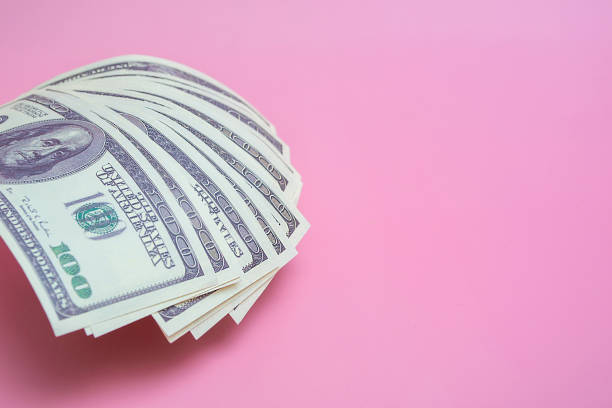 ピンクの背景に100ドル紙幣、コピースペースとクローズアップ - currency paper currency wealth one hundred dollar bill ストックフォトと画像