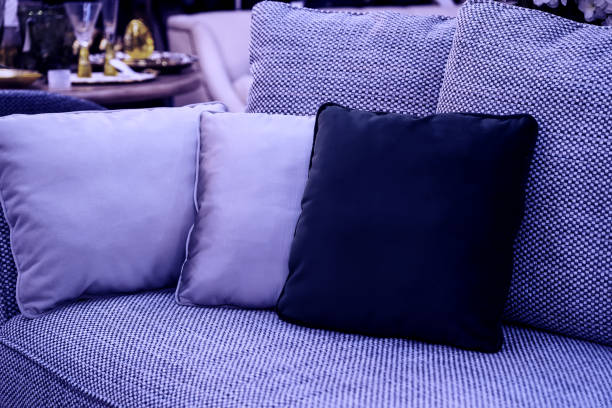 bild getönt in farbe des jahres 2022 sehr peri. kissen auf gemütlichem violettem sofa. kissen auf lässiger couch im wohnzimmer - cushion pillow textile luxury stock-fotos und bilder