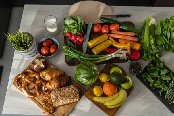 Bunch of vegetables and bread on the kitchen counter in modern apartment.