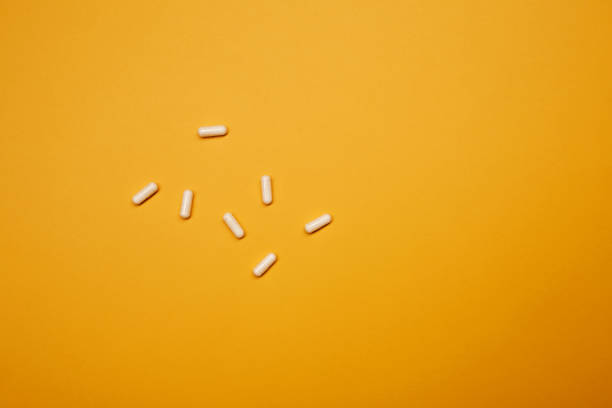 istock Medicament tablet white capsule pills medicine on the yellow background 1366664468