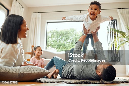 istock Shot of a young family playing together on the lounge floor at home 1366667952