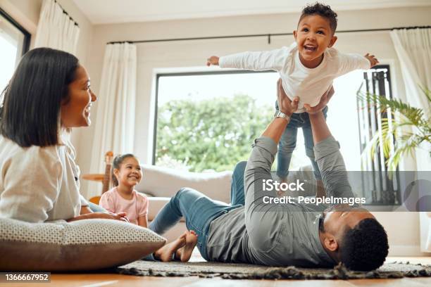 Shot Of A Young Family Playing Together On The Lounge Floor At Home Stock Photo - Download Image Now