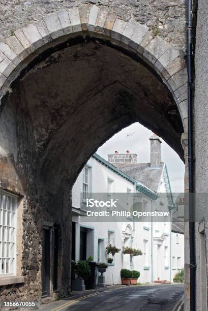 Street Of Old Picturesque Houses Through The Arch Of The Medieval Gatehouse In The Village Of Cartmel In Cumbria Stock Photo - Download Image Now