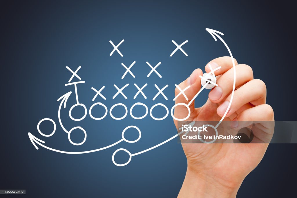 Coach Drawing American Football Game Playbook Coach drawing american football or rugby game playbook, strategy and tactics with white marker on blue background. Strategy Stock Photo