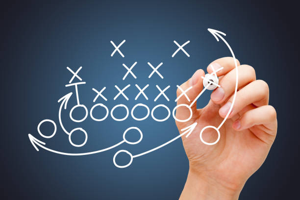 Coach Drawing American Football Game Playbook Coach drawing american football or rugby game playbook, strategy and tactics with white marker on blue background. offense sporting position stock pictures, royalty-free photos & images