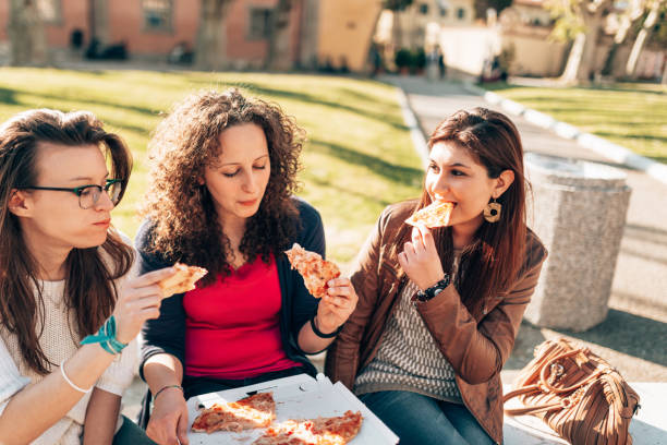 istock friends eating pizza outdoors 1366674738
