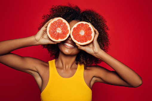 Beautiful afro woman holding a grapefruit