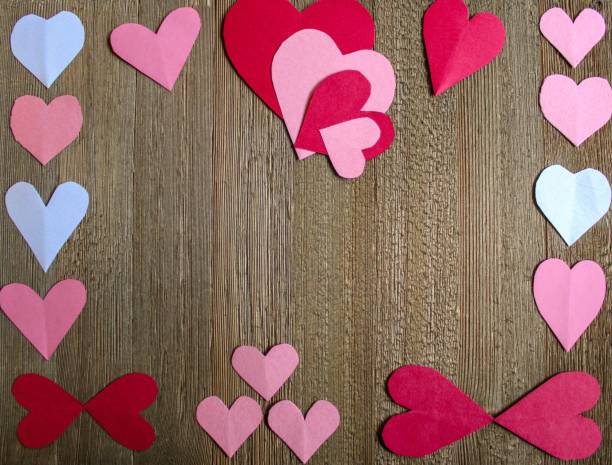 istock paper hearts on warm rustic wood background 1366677293