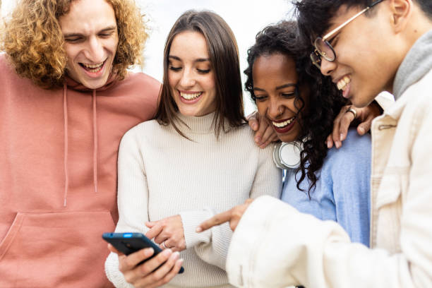 istock Millennial people laughing together while watching funny content on phone app 1366678702