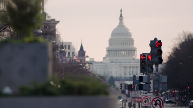 U.S. Capitol In Washington D.C. Out-Of-Focus With Traffic Arrows Turning Red In Foreground