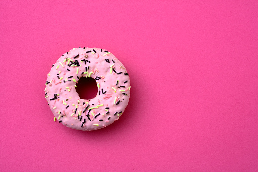 Sweet pink donut on pink background