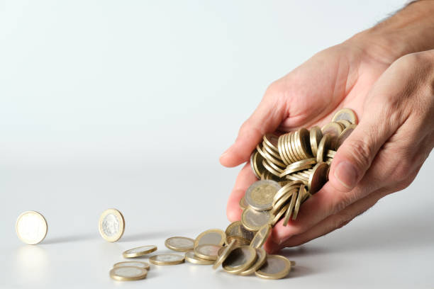 man's hand dropping pile of moving coins on white background man's hand dropping pile of moving coins on white background silver gold ira custodians stock pictures, royalty-free photos & images