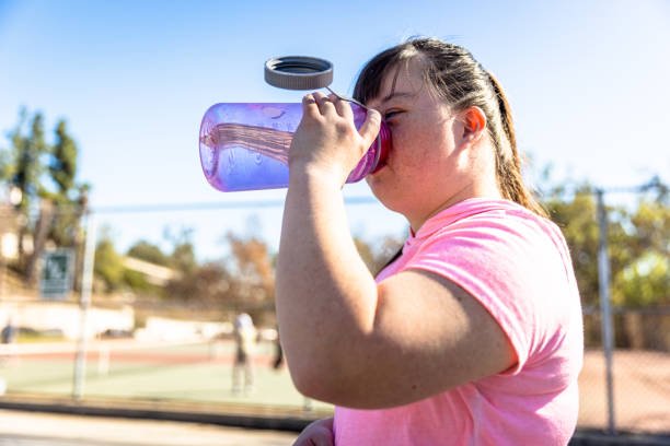 istock Girl with Down's Syndrome Drinking Water Bottle 1366683794