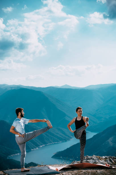 istock Two people is practicing yoga in high mountains 1366683837