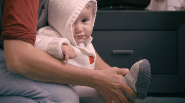 istock Mother dressing up baby at home before playing, close up. 1366685575