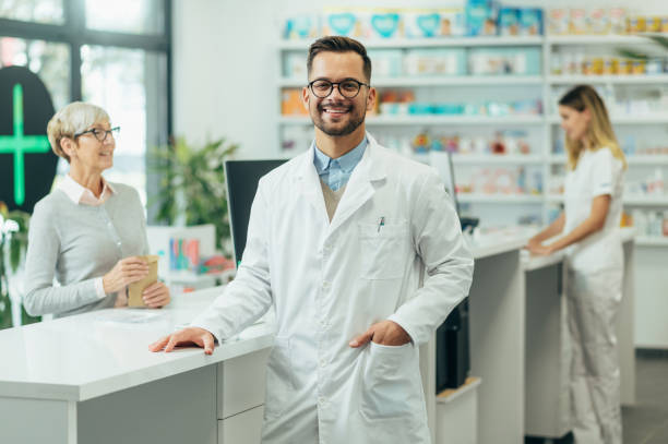 Young female pharmacist posing while working in a pharmacy stock photo
