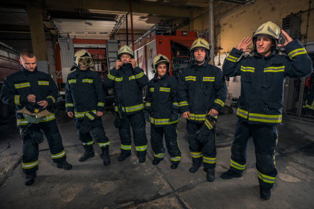 istock Portrait of firefighters standing by a fire engine. 1366686294