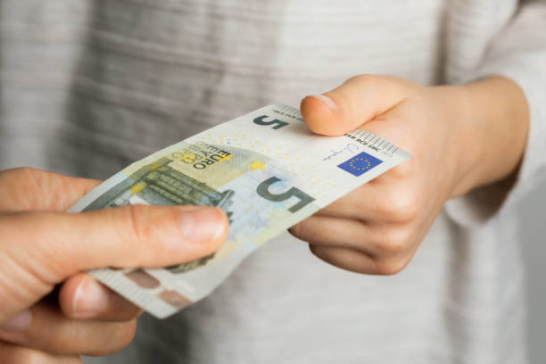 Pocket Money Mother is giving her daughter 5 euro pocket money. allowance stock pictures, royalty-free photos & images